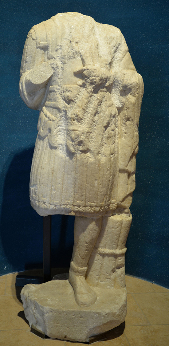 Staty i marmor från ca 100- eller 200-talet e.Kr. Den föreställer en högt uppsatt man i paraduniform. Statyn stod en i gång i den södra delen av militärstaden i Aquincum.